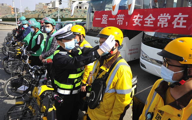 乌鲁木齐市天山区交警大队民警为外卖骑手讲解头盔佩戴规范。新华社资料