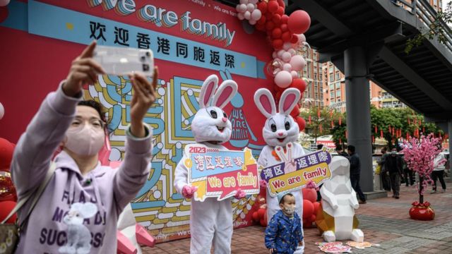 Travellers take photos out of the Futian Port between mainland China and Hong Kong as China further optimizes its regulations on travel between the mainland and Hong Kong and Macao on January 8, 2023 in Shenzhen